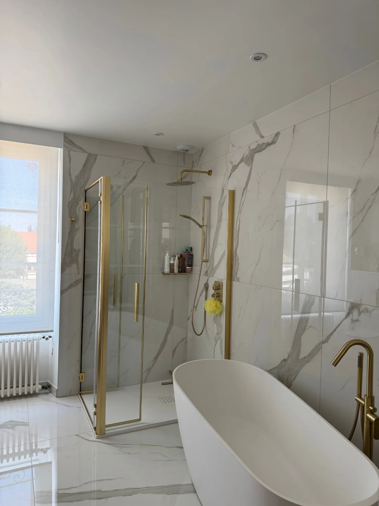 Salle de bains carrelée en marbre blanc avec douche à l'italienne, réalisation Eveillard Carrelages